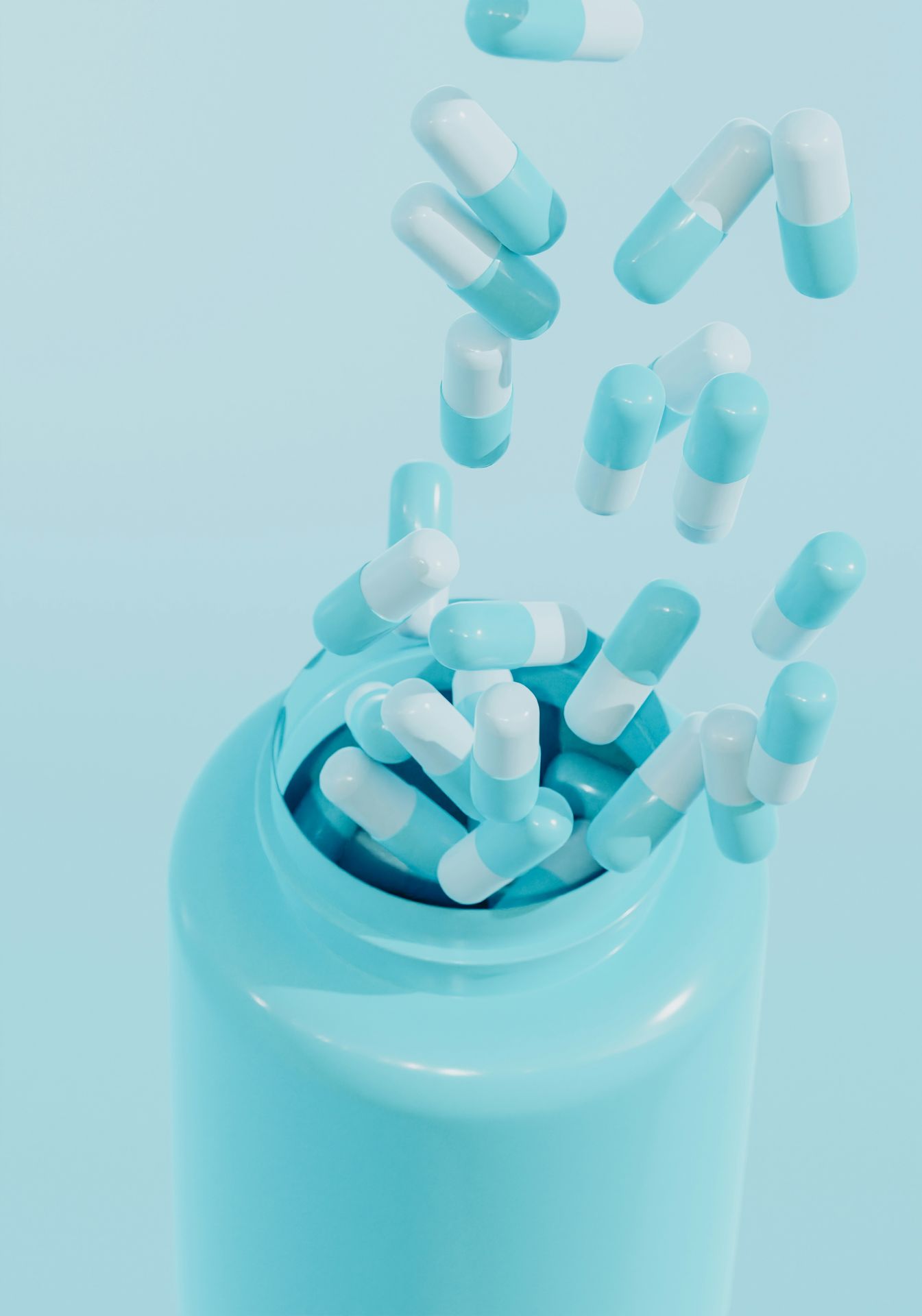 Blue and white capsules being filled into a bottle