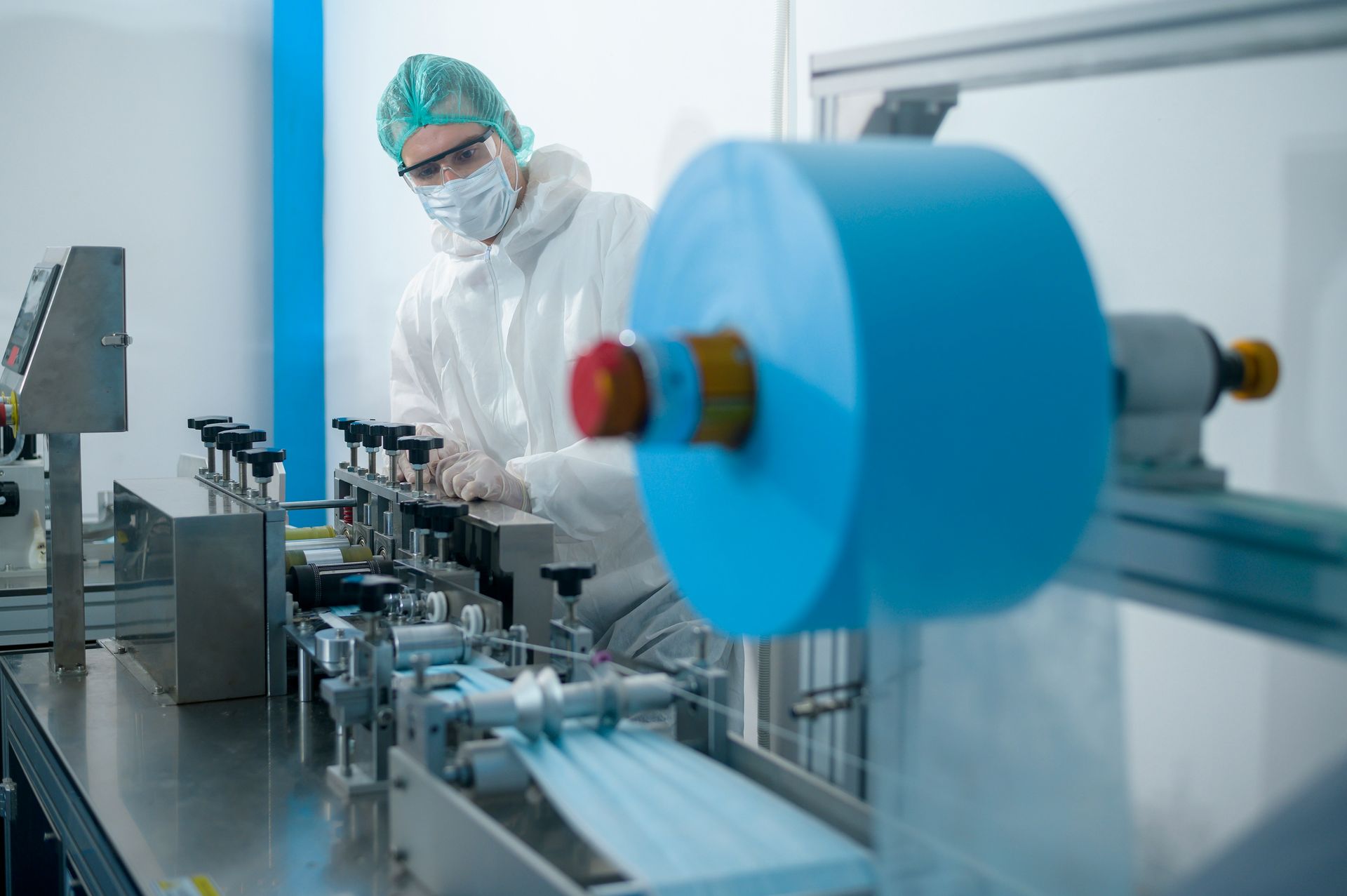 Cleanroom operator reviewing documentation beside production equipment